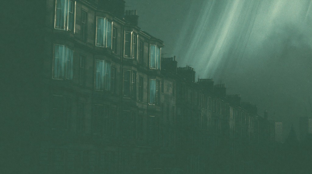 Scottish tenement windows glowing at night